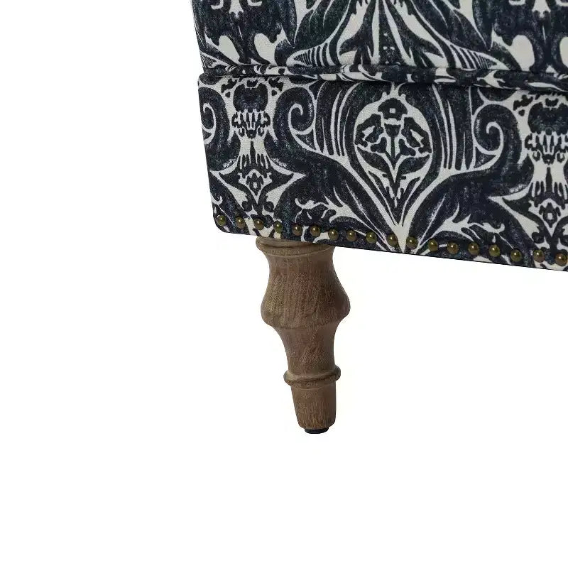 Fauteuil rembourré en bois avec motif floral, accoudoirs à panneaux et dossier en forme de bosse de chameau.